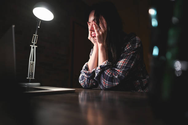 Tired person working on laptop.