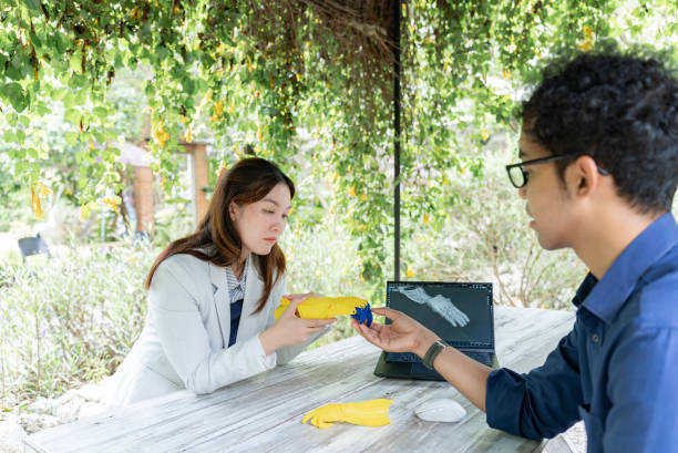 In the midst of the tranquil outdoors, two Asian mid-adult coworkers, one man and one woman, dressed in formal attire, discussing their work with utmost seriousness, their focus solely directed towarding the workpiece in front of them. en medio de la tranquilidad al aire libre, dos compañeros de trabajo asiáticos de mediana edad, un hombre y una mujer, vestidos con atuendos formales, discuten su trabajo con la mayor seriedad, su enfoque se dirige únicamente hacia la pieza de trabajo f
