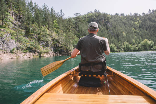 istock Rear view of man paddling canoe 2155440444