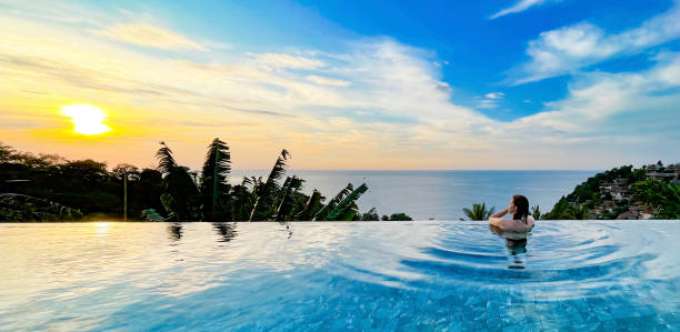 istock Woman Relaxing in Infinity Pool at Sunset with Ocean View 2155444857