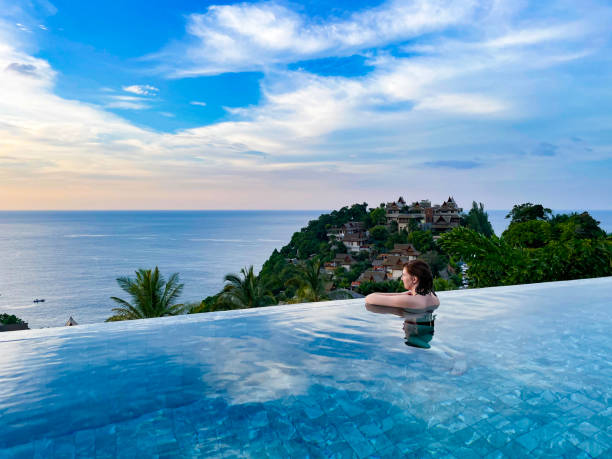 istock Woman Relaxing in Infinity Pool at Sunset with Ocean View 2155445366
