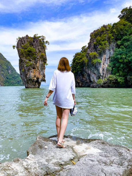 istock Woman Posing on Rocks by the Sea with Scenic Cliffs 2155446085