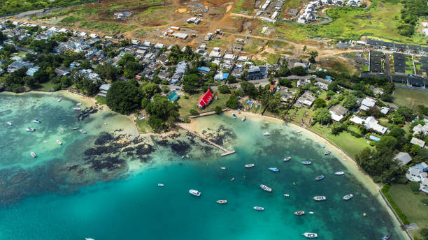 A breathtaking aerial photo capturing the picturesque Cap Malheureux coastline in Mauritius. Sailboats with white sails add a touch of serenity to the scene. Cap Malheureux is a village in Mauritius. It's located in the Rivière du Rempart District.