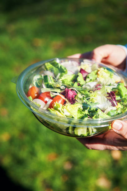 istock Eating Mixed Salad Bowl Packed in a Plastic Box Outside 2155458141