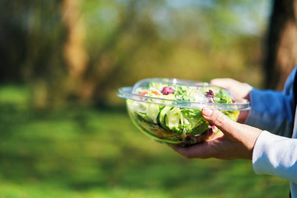 istock Eating Mixed Salad Bowl Packed in a Plastic Box Outside 2155458163