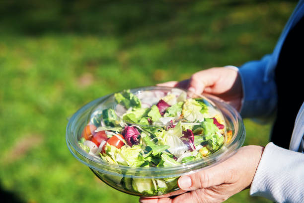istock Eating Mixed Salad Bowl Packed in a Plastic Box Outside 2155458173