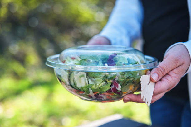 istock Eating Mixed Salad Bowl Packed in a Plastic Box Outside 2155458190