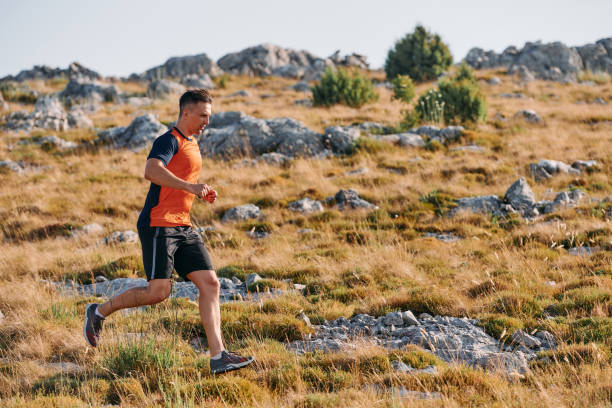 istock Determined Athlete Running Through Rugged Mountain Terrain at Sunrise. 2155458373