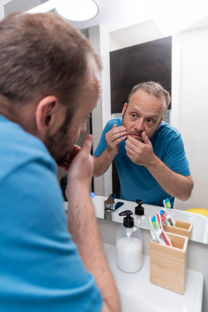 istock Daily Routine: Young Man Looking in the Bathroom Mirror 2155459125