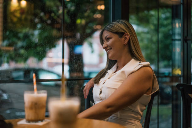 istock Happy woman enjoying coffee smiling in a bar 2155460117
