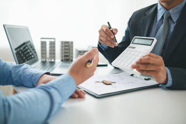 istock Real estate brokers offer attractive promotions customers so they can decide purchase condominium unit for living and as value added asset. Concept of signing real estate purchase contract with dealer 2155461619