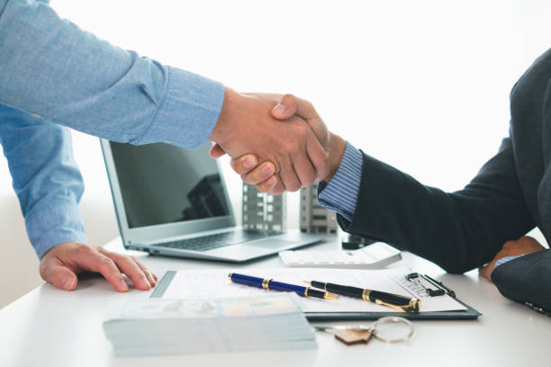 istock Real estate brokers offer attractive promotions customers so they can decide purchase condominium unit for living and as value added asset. Concept of signing real estate purchase contract with dealer 2155461627