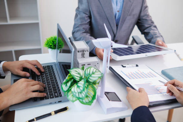 istock Businessmen, investors and electrical engineers discuss clean energy residential projects help reduce global warming and use clean energy from wind and sunlight. concept clean energy projects 2155463695