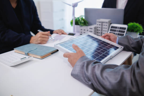 istock Businessmen, investors and electrical engineers discuss clean energy residential projects help reduce global warming and use clean energy from wind and sunlight. concept clean energy projects 2155463697