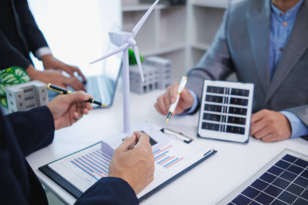 istock Businessmen, investors and electrical engineers discuss clean energy residential projects help reduce global warming and use clean energy from wind and sunlight. concept clean energy projects 2155463748