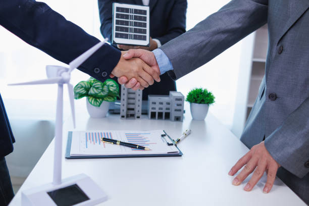 istock Businessmen, investors and electrical engineers discuss clean energy residential projects help reduce global warming and use clean energy from wind and sunlight. concept clean energy projects 2155463783