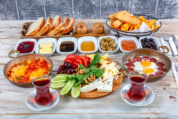istock Traditional delicious modern Turkish cuisine. Plain Turkish breakfast with copper-pan egg dishes, pastries such as börek and bagels, jams, olives, cheeses, vegetables and Turkish tea. 2155464809