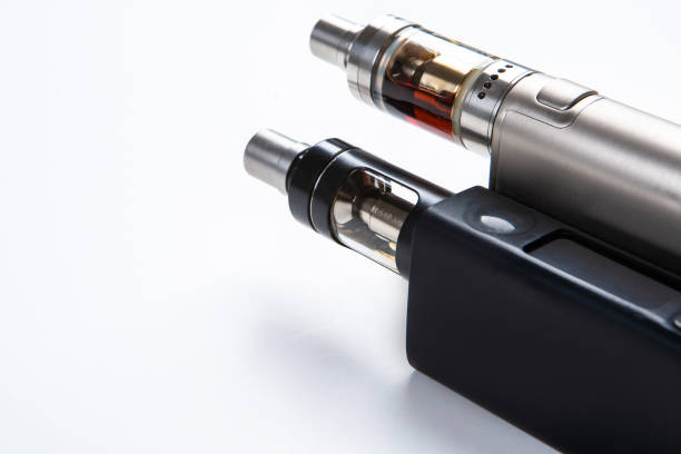 istock Vape. Vaping. Inventory for Vaper. Two electronic cigarettes are lying on the table. Safe smoking. Fighting a bad habit. Reduce nicotine intake. vape gadgets. Safe cigarette. Smoking e-cigarettes. 2155464830