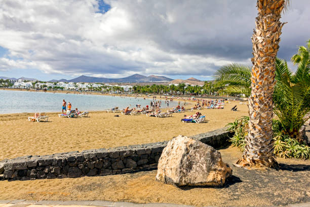 View across the beach at Porta Del Carmen, Lanzarote, Spain.  People can be seen on the beach