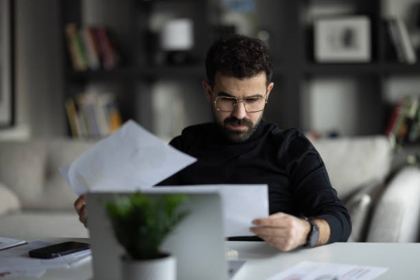 istock Thoughtful young businessman analyzing financial paper data. 2155467210
