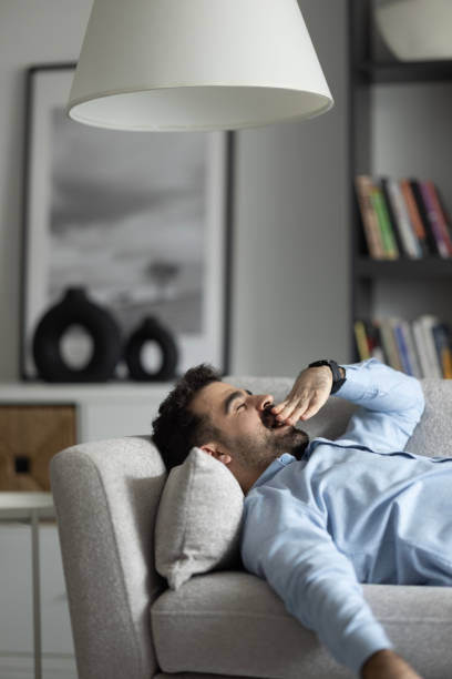 istock Calm pleasant man napping daydreaming alone on couch. 2155467474