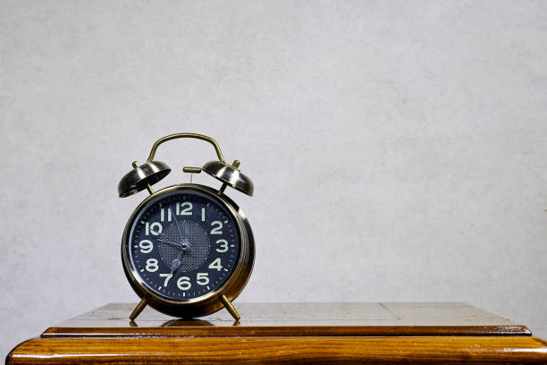 istock alarm o'clock showing 7 o'clock on wood table 2155472075