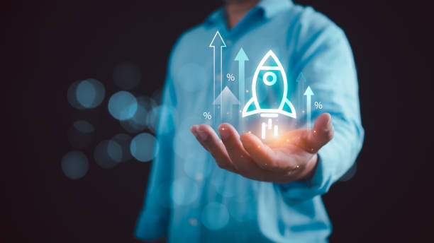istock startup business idea Businessman holds transparent rocket icon launching and soaring with arrow graph. Strategic planning and business success 2155473749