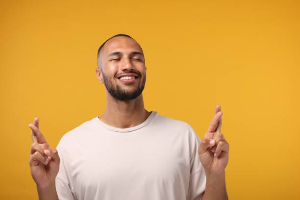istock Happy man crossing his fingers on orange background. Space for text 2155475070