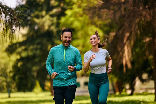 istock Athletic couple laughing and having fun while jogging in nature. 2155475312