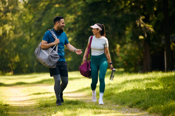istock Cheerful athletic couple communicating while going on sports training in nature. 2155476054