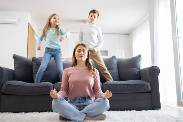 istock Meditating mother with energetic kids at home 2155478382