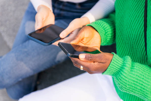 istock hands of two women using mobile phone 2155478940