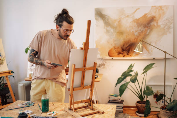 istock A creative tattooed artist painting an artwork on easel at atelier. 2155479082