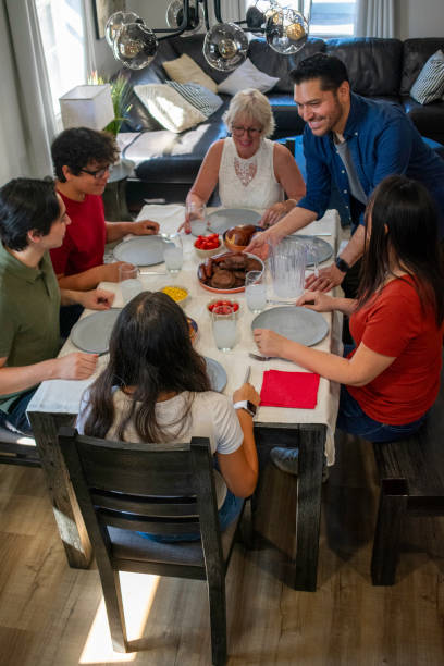 istock Multigenerational multiracial family sits at table eating dinner 2155480937