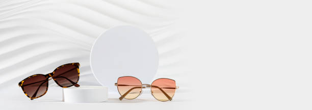 istock Optic store advertisement banner. Sunglasses with metallic Frame and trendy tortoiseshell frame sunglasses on podiums on white Background. Minimal style. Copy space. Optic store discount, sale banner. 2155481497