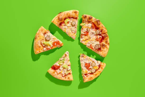 istock Chicken Caesar pizza with lettuce, tomatoes, capers, and sauce on a vibrant green background. Minimalist style, top view of sliced pizza 2155482258