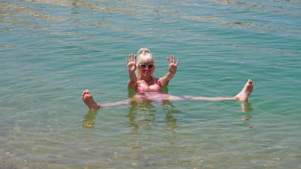 istock Playful child floating in clear lake water 2155483540