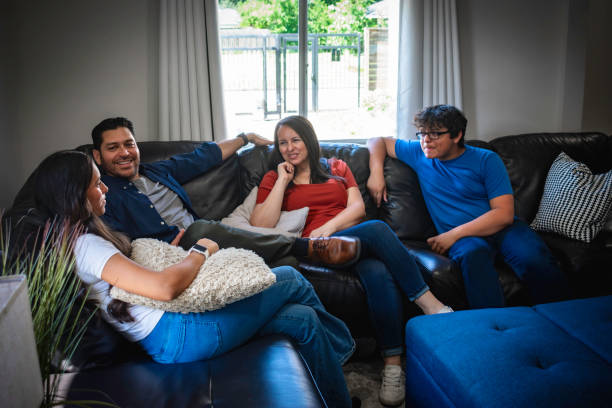 istock Family of four relaxes on couch 2155483930