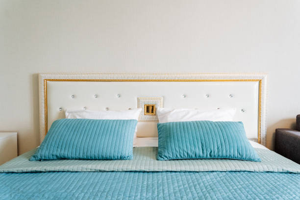 istock Aqua bedding and pillows on wood bed frame in rectangular bedroom fixture 2155484600