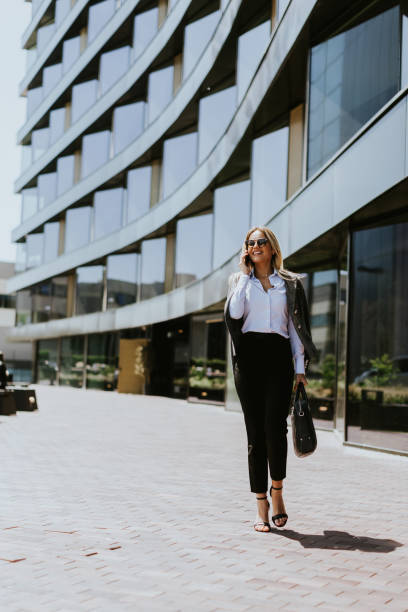 istock Business professional walking outside modern office building on a sunny day 2155484852
