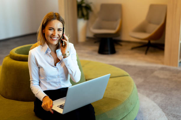 istock Businesswoman working on laptop while on a call in a modern office 2155484864