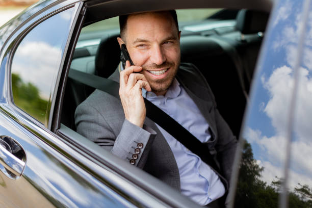 istock Joyful man sharing laughter on a phone call while driving in daylight 2155484919