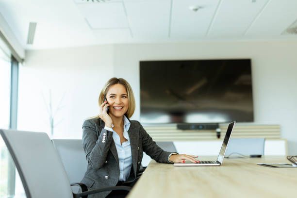 istock Professional woman in modern office enjoying a phone call midday 2155484974