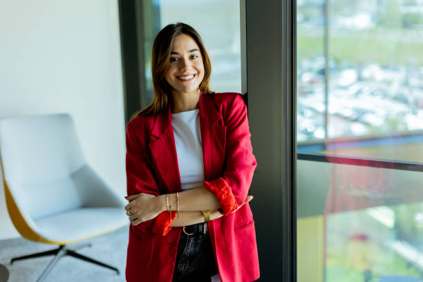 istock Confident young professional in red blazer smiling at modern office environment 2155485030