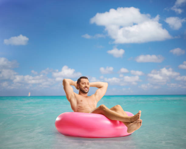 istock Handsome young man in the sea enjoying in a swimming ring 2155485375