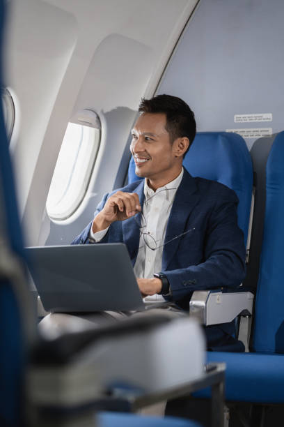 istock Asian businessman enjoying enjoys a coffee comfortable flight while sitting in the airplane cabin, Passengers near the window. 2155488360