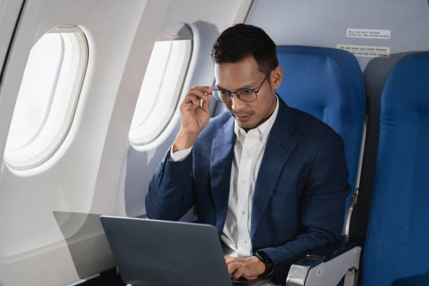 istock Tired asian man with headache feeling sick while sitting in the airplane , Passengers near the window. 2155488485