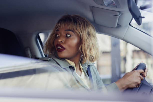 istock Woman Driving Car and Looking Back Over Her Shoulder 2155492177