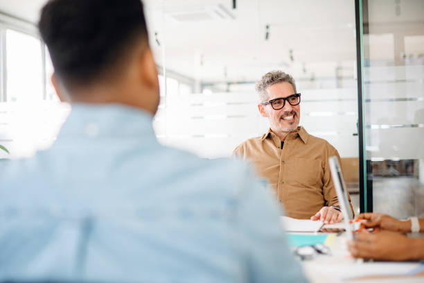 istock A confident mature male professional involved in discussion with colleagues 2155493351