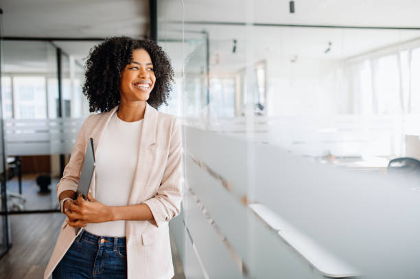 istock A young professional woman stands confidently in a modern office 2155493394